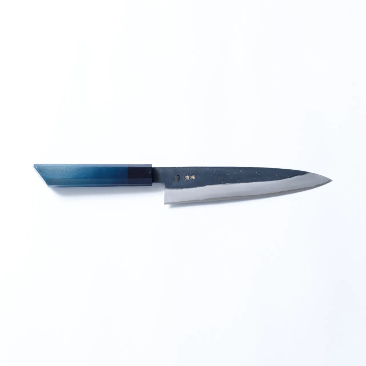 Cuchillo Gyuto artesanal de 210mm con hoja de acero al carbono forjado y mango teñido en añil, fabricado por maestros de Sakai y Tokushima.